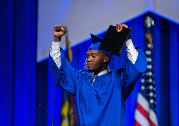 A student walks across the stage during Commencement.