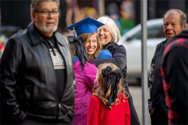 A graduate hugs her supporters.