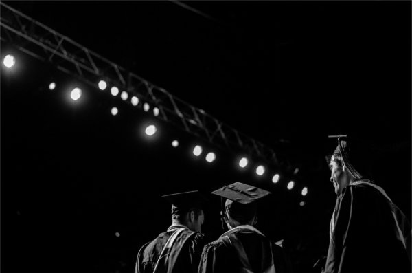 Graduates stand in line, preparing to take the stage.