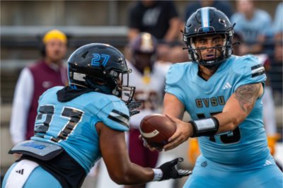 Quarterback Avery Moore hands the ball off to running back Khalil Eichelberger.