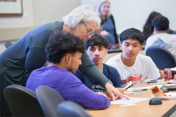 Marianne Essing, from Mercantile Bank, assists TRIO Upward Bound Grand Rapids seniors during a Money Masters program at the L. William Seidman Center. 