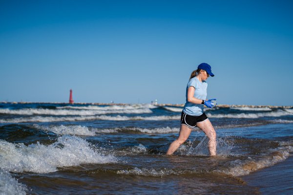 Lexy Porter takes a water sample from Lake Michigan in Muskegon.