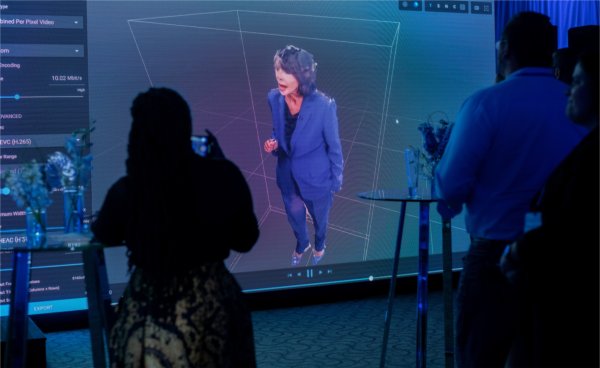 A digital 3D representation of President Philomena V. Mantella delivers remarks to the audience as part of GVSU's "The Blue Dot Experience," event for Tech Week GR.