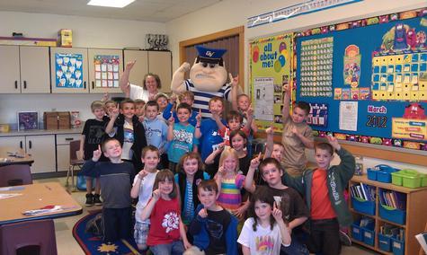 Louie and Laker, Grand Valley alumna Tanya Darling, '03 and '08, and her second-grade students from Courtade Elementary School give thumbs-up to reading.