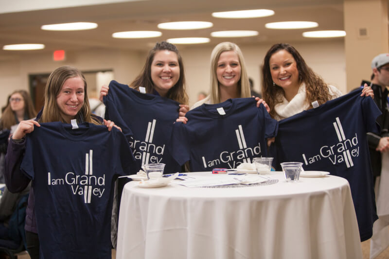 A photo of students holding up their t-shirts.