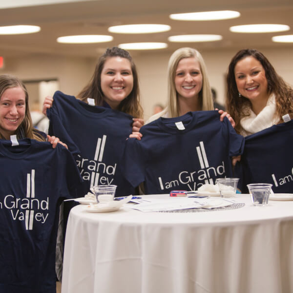 A photo of students holding up their t-shirts.