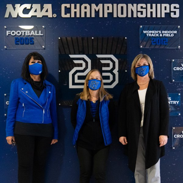 from left President Mantella, Joan Boand and Keri Becker standing in front of display wall