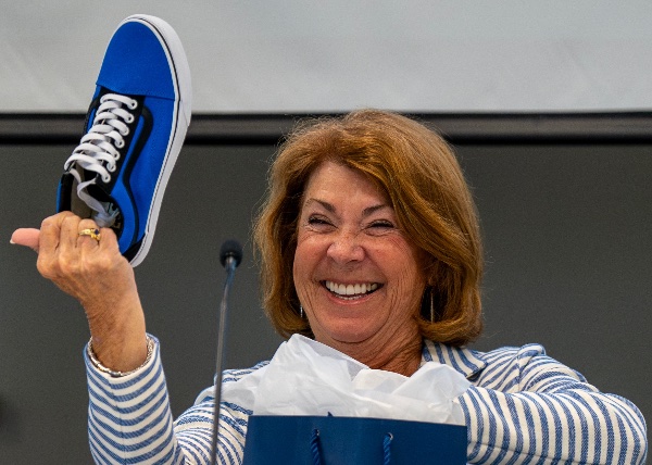 Outgoing GVSU Board Chair Susan Jandernoa smiles as she holds up a commemorative sneaker given as a gift for concluding her two years of service as chair. 