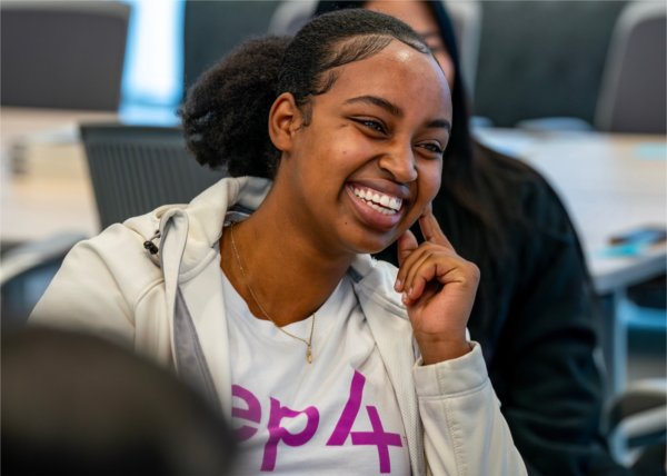 Finance and accounting major Joyeuse Murerwa smiles during a conversation with Carla Harris and President Philomena V. Mantella