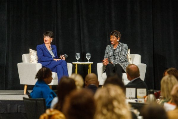 President Philomena V. Mantella and Carla Harris react to a question from the audience during an event with the Economic Club of Grand Rapids.