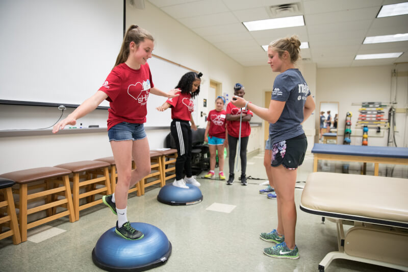 Campers testing their balance during a physical therapy workshop.