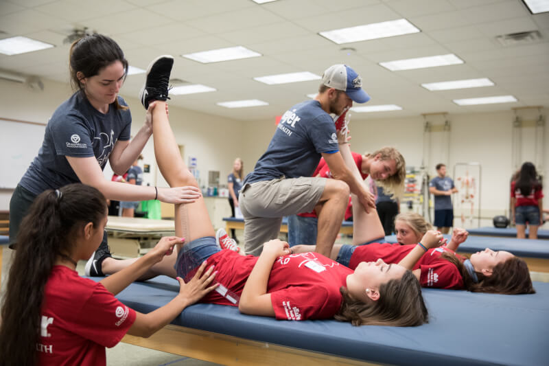 Students measureing range of motion during a physical therapy workshop.