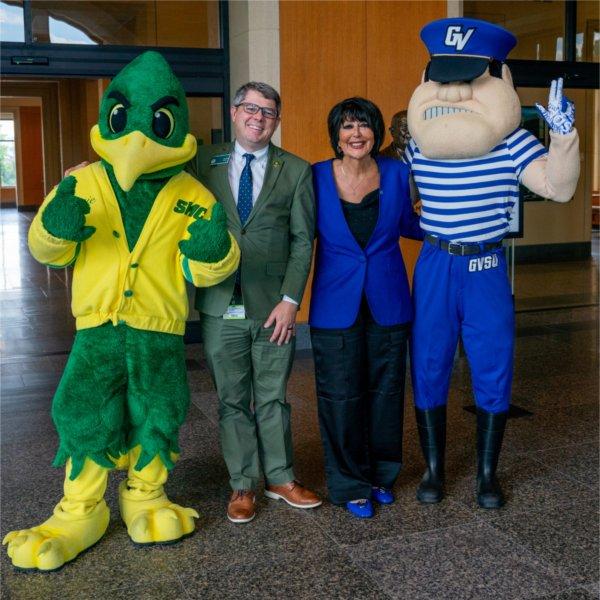 Louie the Laker at right and the SMC road runner mascot at left stand next to SMC president and President Mantella