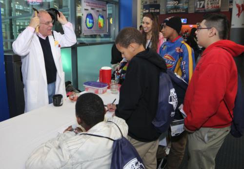 Rick Albrecht, professor of movement science and coordinator of the sport leadership program, talks to students during a science fair at Van Andel Arena November 6.