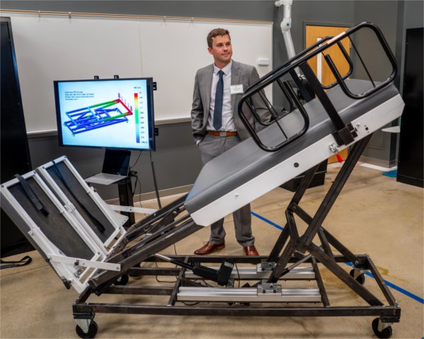  Tyler Williams stands near the &ldquo;Adjustable Physical Therapy Table&rdquo; as part of the Senior Project Showcase