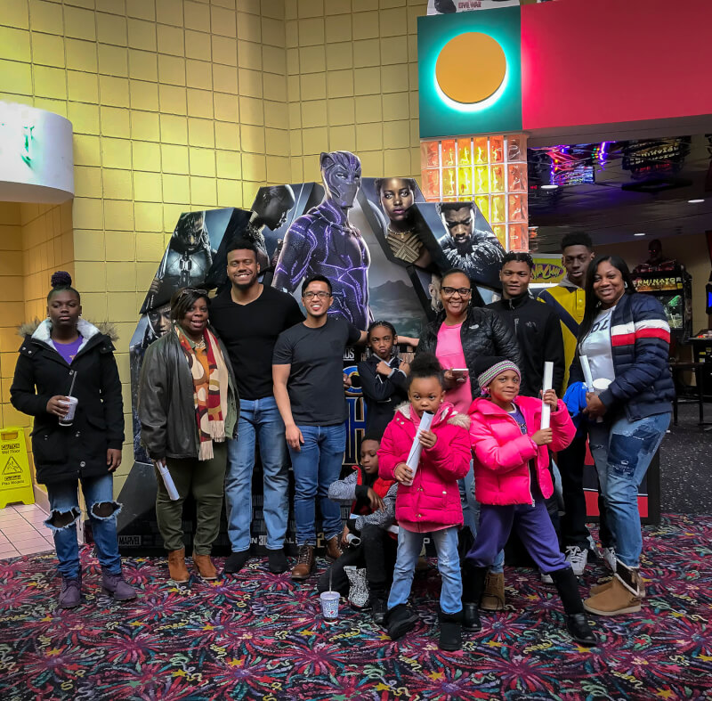 group of people in front of movie cutout of The Black Panther