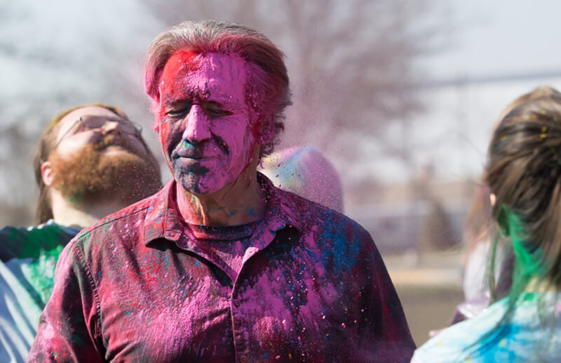 man covered in colored powder