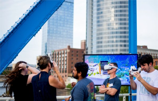 Guests try on headgear for an extended reality experience during a Tech Week GR event on the Blue Bridge in 2023. 