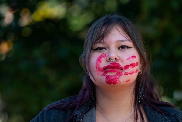  A red hand print is shown on the face and over the mouth of a college student.