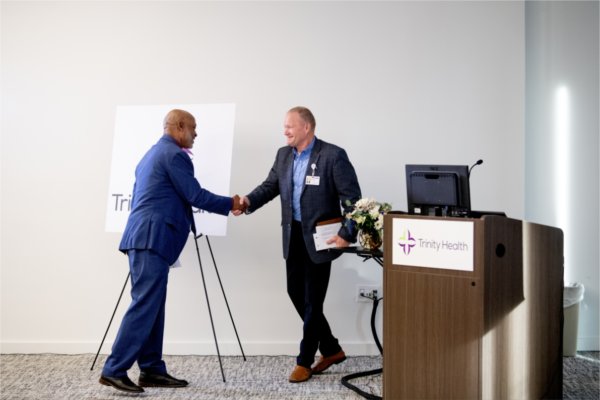 two people shake hands next to a podium