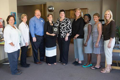 Ann Sheehan, assistant dean for practice, fifth from left, accepts an award from Priority Health�s Megan Whitmore, fourth from left, on behalf of the GVSU Family Health Center.