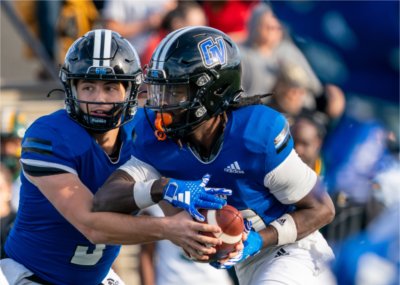 Quarterback Vinnie Meschi hands the ball to a teammate.