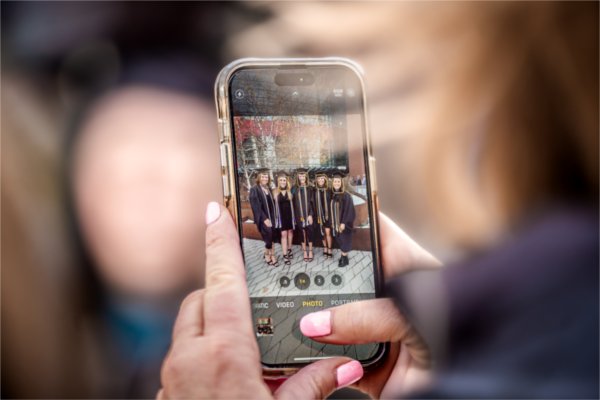  A detail photo of a cellphone picture of a group of graduates. 