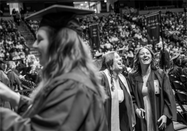  Two graduates laugh together. 