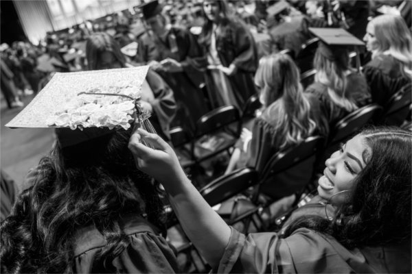  One graduate fixes the tassel of another. 