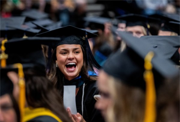  A graduate laughs among other graduates. 