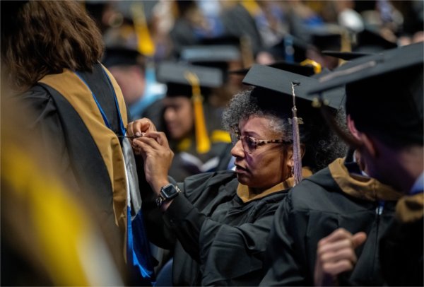  A graduate fixes the stoll of another. 