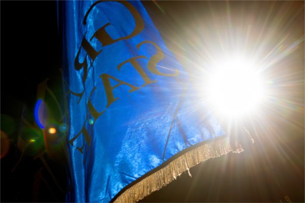  A burst of light is seen behind a Grand Valley State University blue flag. 