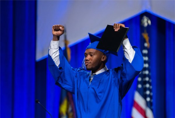  A graduate reacts to receiving their diploma. 