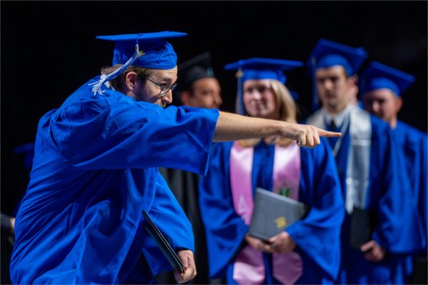   A graduate reacts to receiving their diploma. 