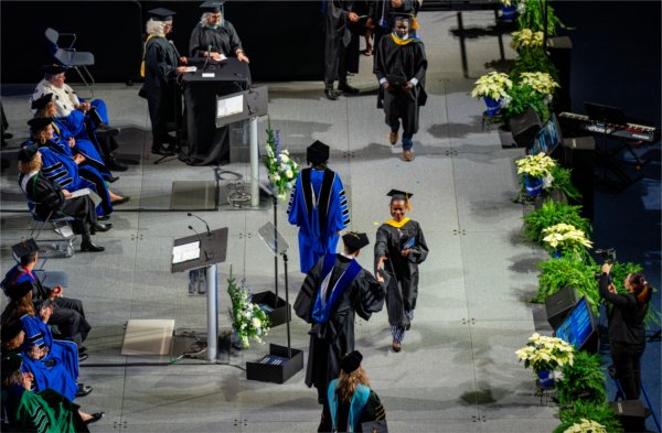  A graduate crosses the stage for their diploma. 