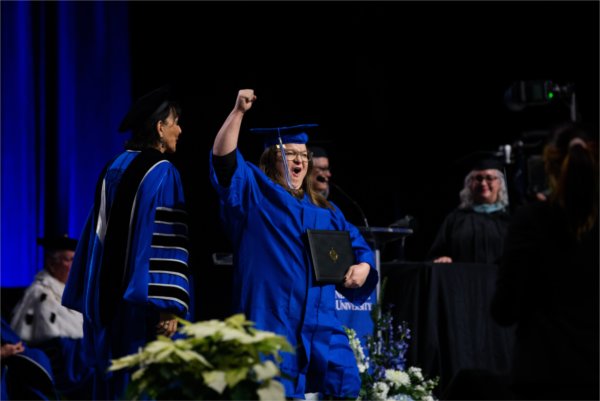   A graduate reacts to receiving their diploma. 