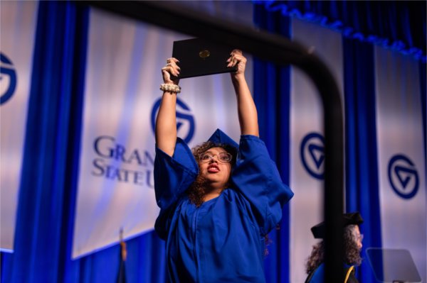   A graduate reacts to receiving their diploma. 