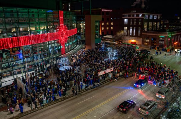  A large crowd of graduates and their supporters spill out of an arena at night. 