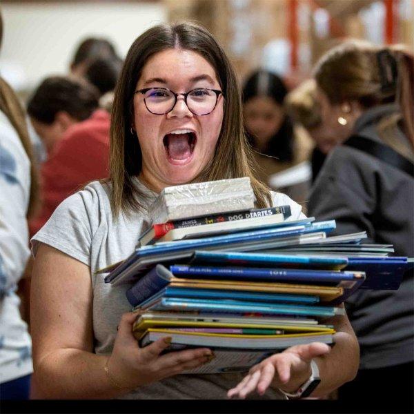 Rhianna Furness, a senior special education major, reacts to the stack of books she picked out.