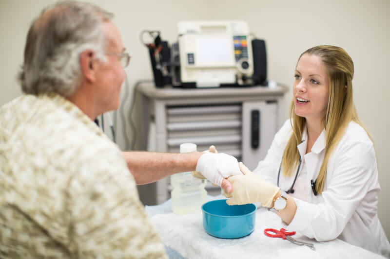 nursing student providing care to patient's hand
