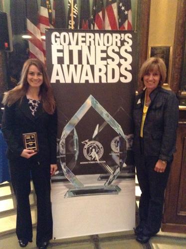 Lindsey DesArmo, left, and Sue Sloop accept a Governor's Fitness Award on behalf of Grand Valley April 24 in Lansing.