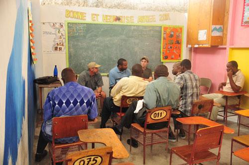 Peter Wampler and Chris Hendree, from Admissions, talk with students at a Haitian school.