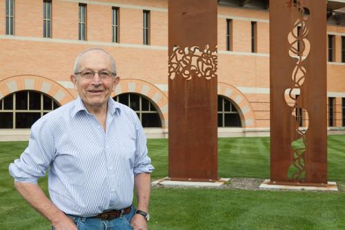 Cyril Lixenberg with his sculpture "Magela - S" located on the Pew Grand Rapids Campus. Photo by Bernadine Carey-Tucker.