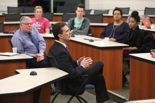 Grand Rapids Police Chief David Rahinsky speaks to students in an Intercultural Training Certificate course January 22. At left is Edward Edwardson, affiliate faculty of criminal justice.