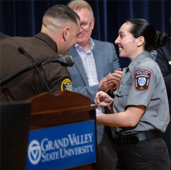 GVSU Police Academy recruit shakes hands with instructors and leadership