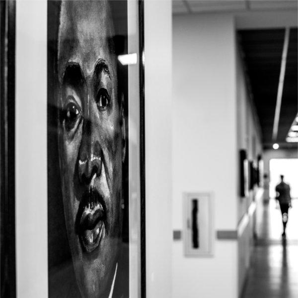 portrait of Dr. King in hallway at DCIH, person walking down hall seen from back